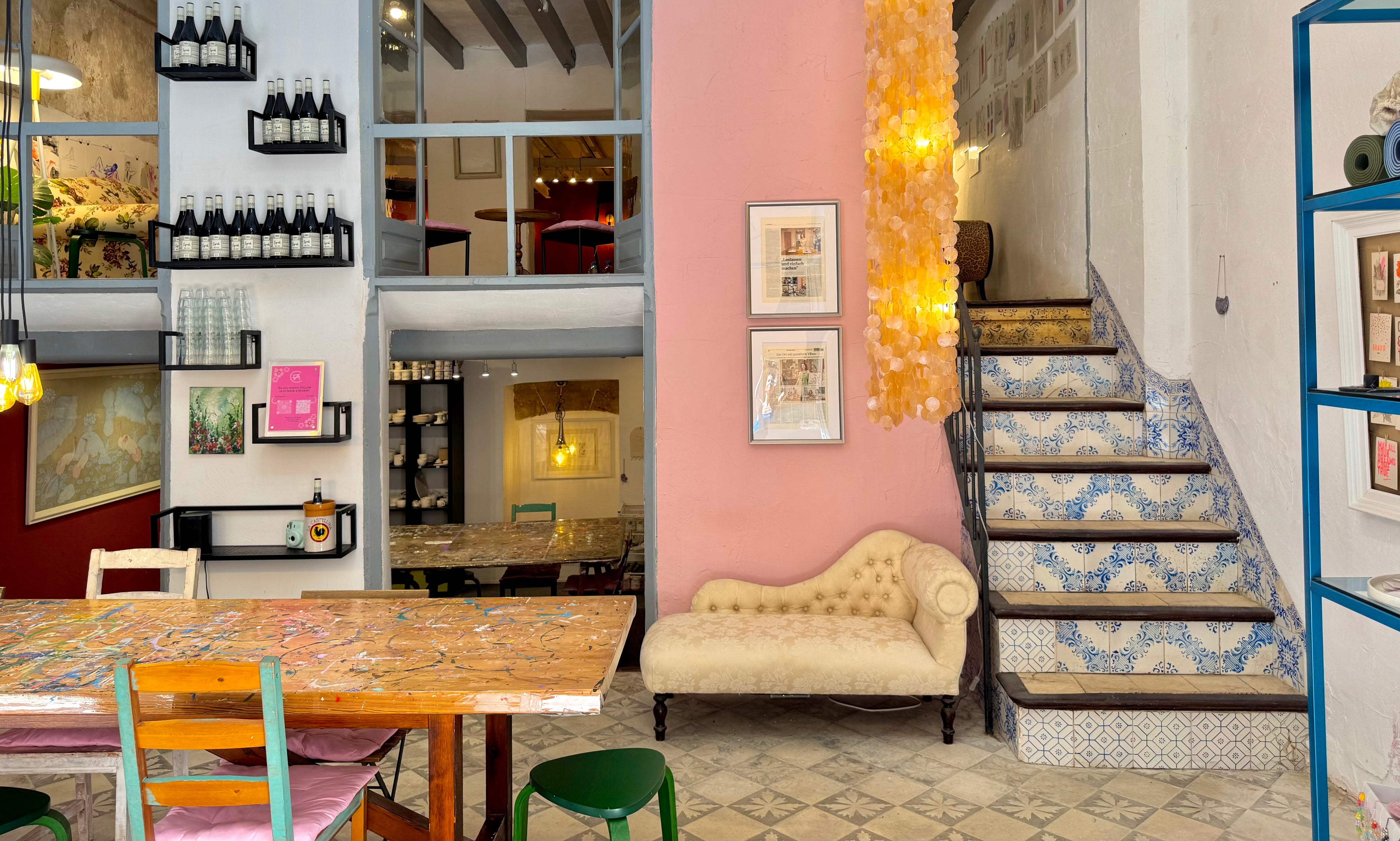 Interior of a stylish art studio with a table, chairs, and decorative elements.