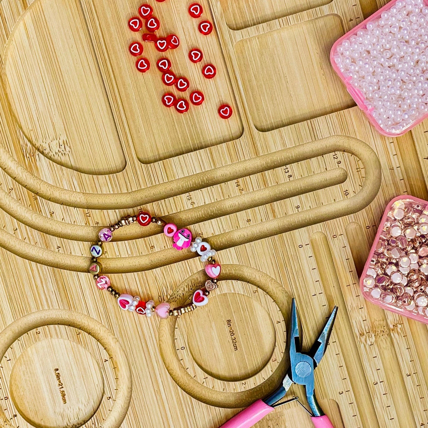 Beaded bracelet on a wooden surface with tools and beads