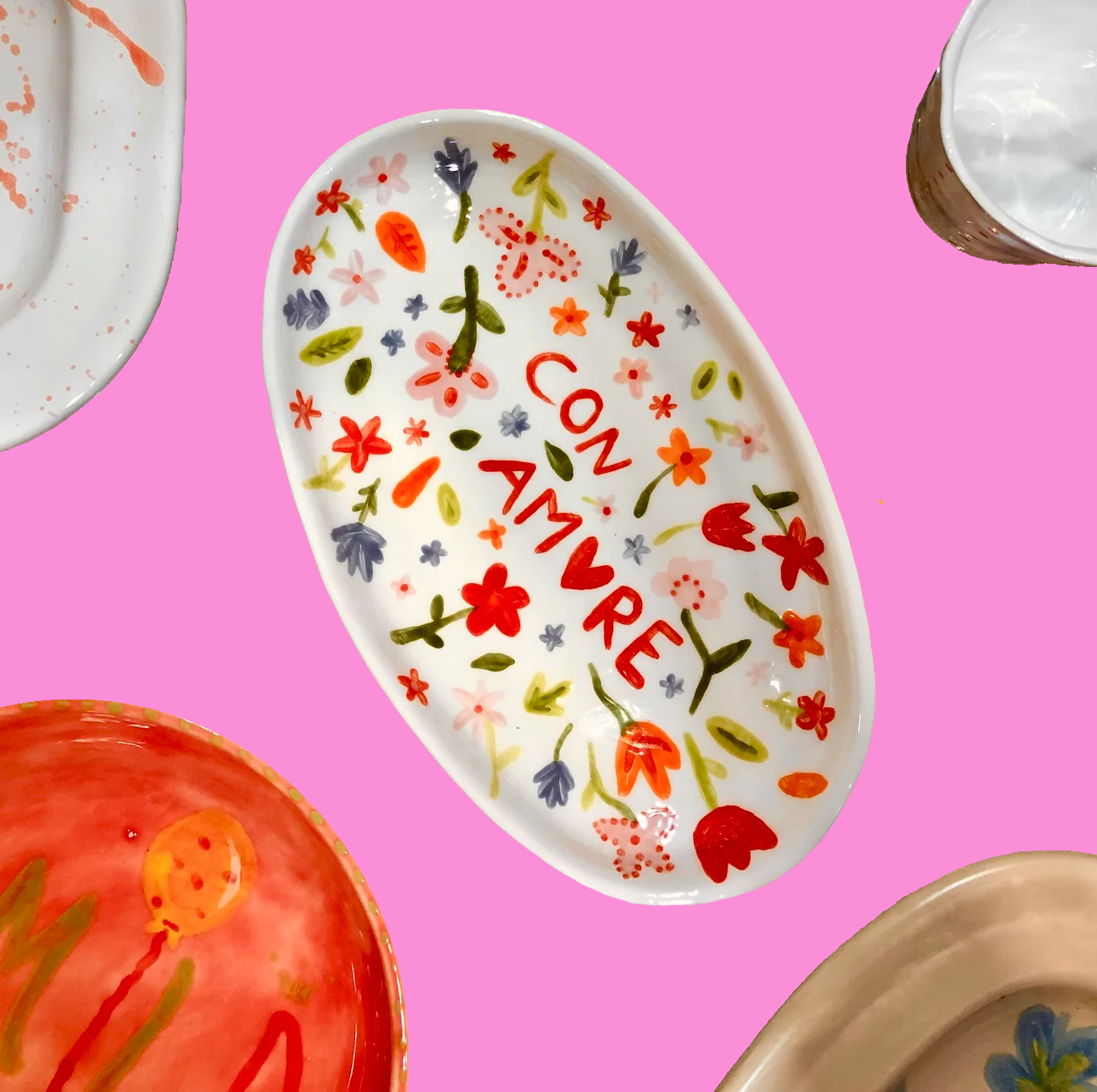 Decorative plate with floral patterns and 'CON AMORE' text on a pink background
