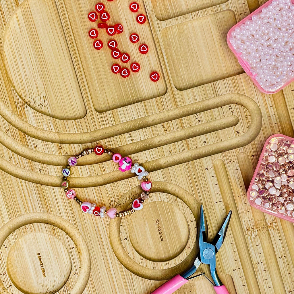 Beaded bracelet on a wooden surface with tools and beads