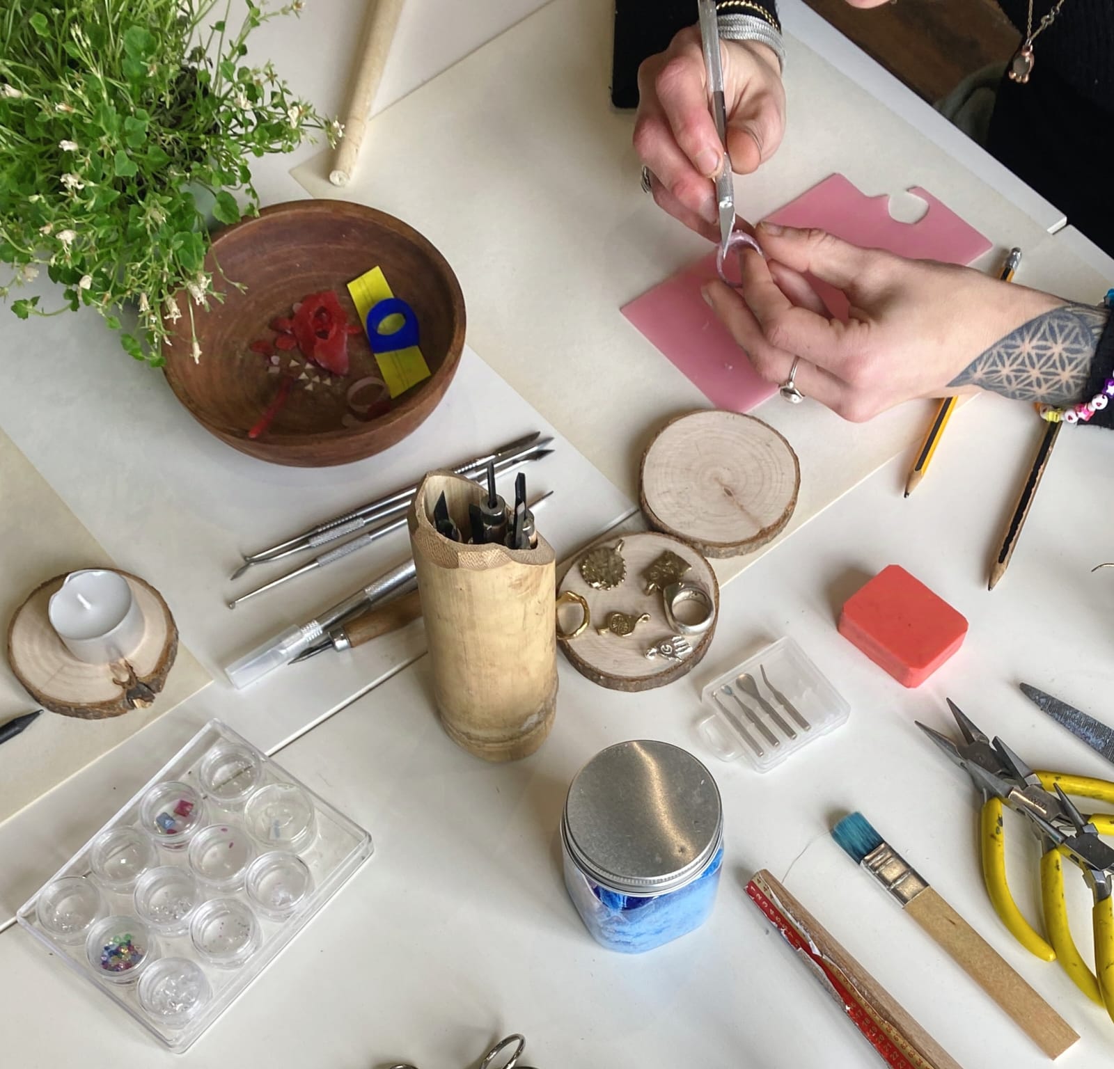 Crafting wax rings on a table with various tools and materials.