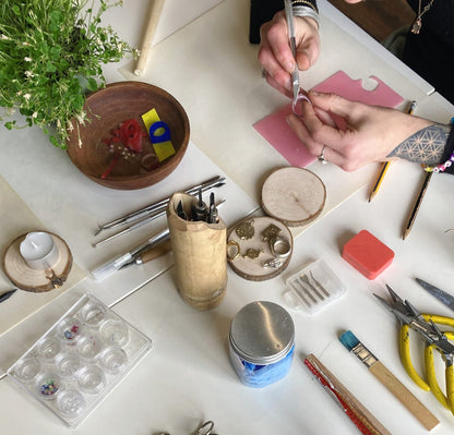 Crafting wax rings on a table with various tools and materials.